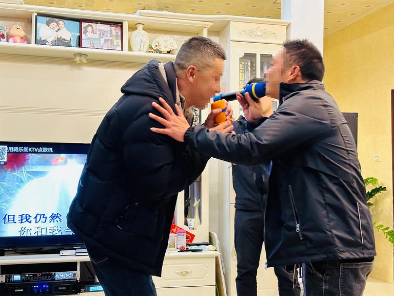 Two of the family uncles enjoying some karaoke. Faces have been pixelated for privacy.