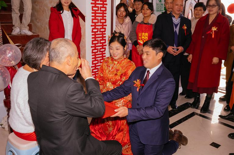 A member of the family drinking tea as offered by the groom. Faces have been pixelated for privacy.