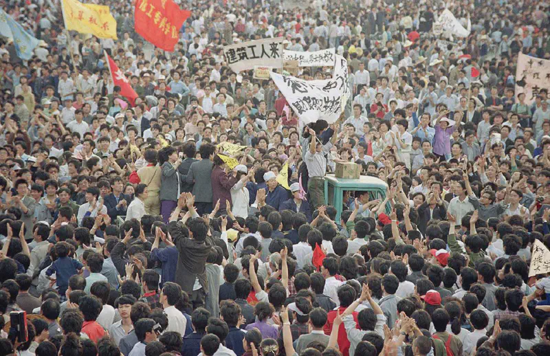 A truck is almost buried in people as it makes its way through the crowd of thousands gathered in Tiananmen Square in a pro-democracy rally, on May 17, 1989. AP Photo/Sadayuki Mikami