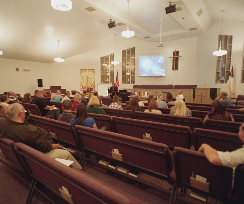 The Davis County Tea Party group held regularly meetings at local civic or religious buildings. Members here are pictured at their semi-regular location at the Mountain Road Evangelical Presbyterian Church. Each meeting was started with a prayer and was followed by the pledge of allegiance. The focus of meetings were varied but would usually include a review of a topic central to Tea Party doctrine.