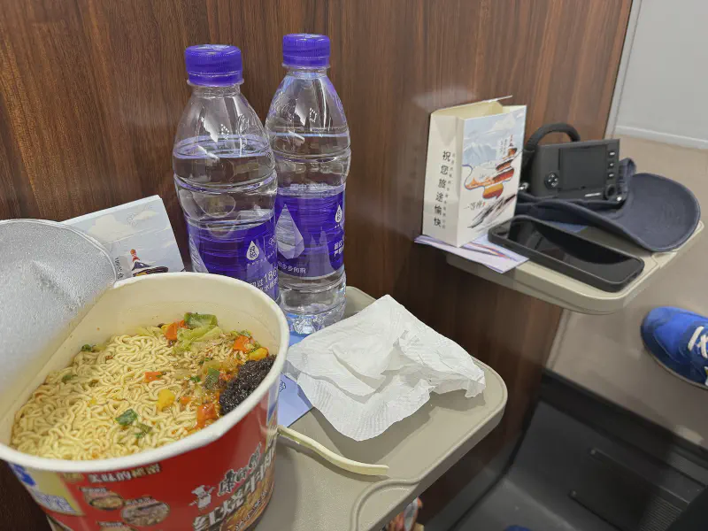 It is common for trains in China to have hot water dispensers for making hot tea or instant noodles. I saw several people wandering around with stacks of instant noodles looking for the train car with the dispenser.